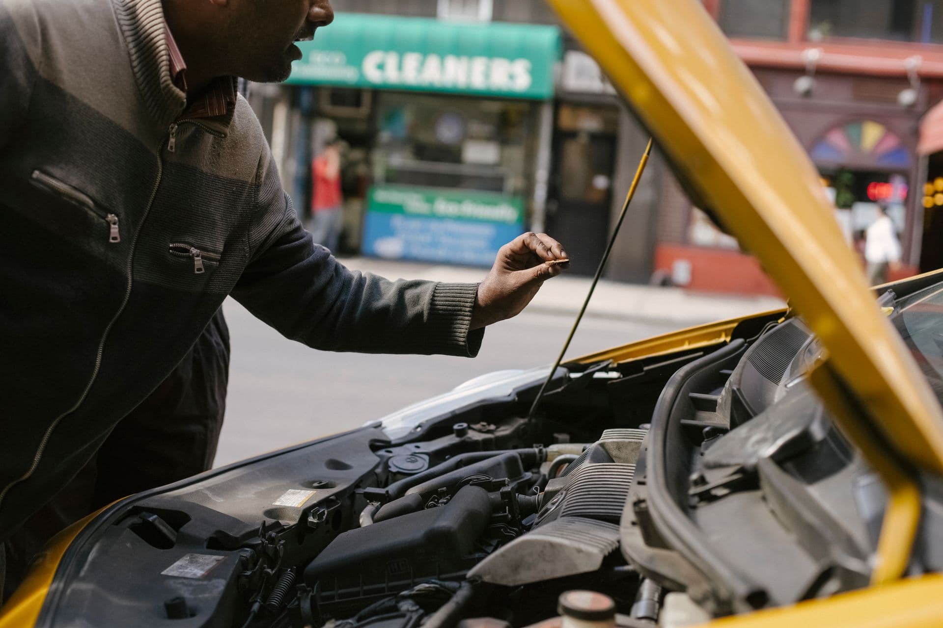 A car stopped at the kerbside of a city street with its bonnet open after a breakdown